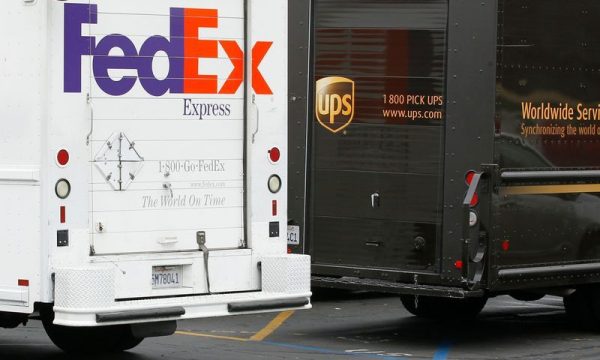 A FedEx truck is parked next to a UPS truck as both drivers make deliveries in downtown San Diego, California March 5, 2013.  REUTERS/Mike Blake